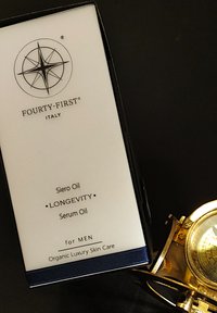 Zwarte box van het Siero Oil longevity serum met een wit etiket, voorzien van een kompaslogo. De tekst bevat "voor HEREN" en "Organische Luxe Huidverzorging."