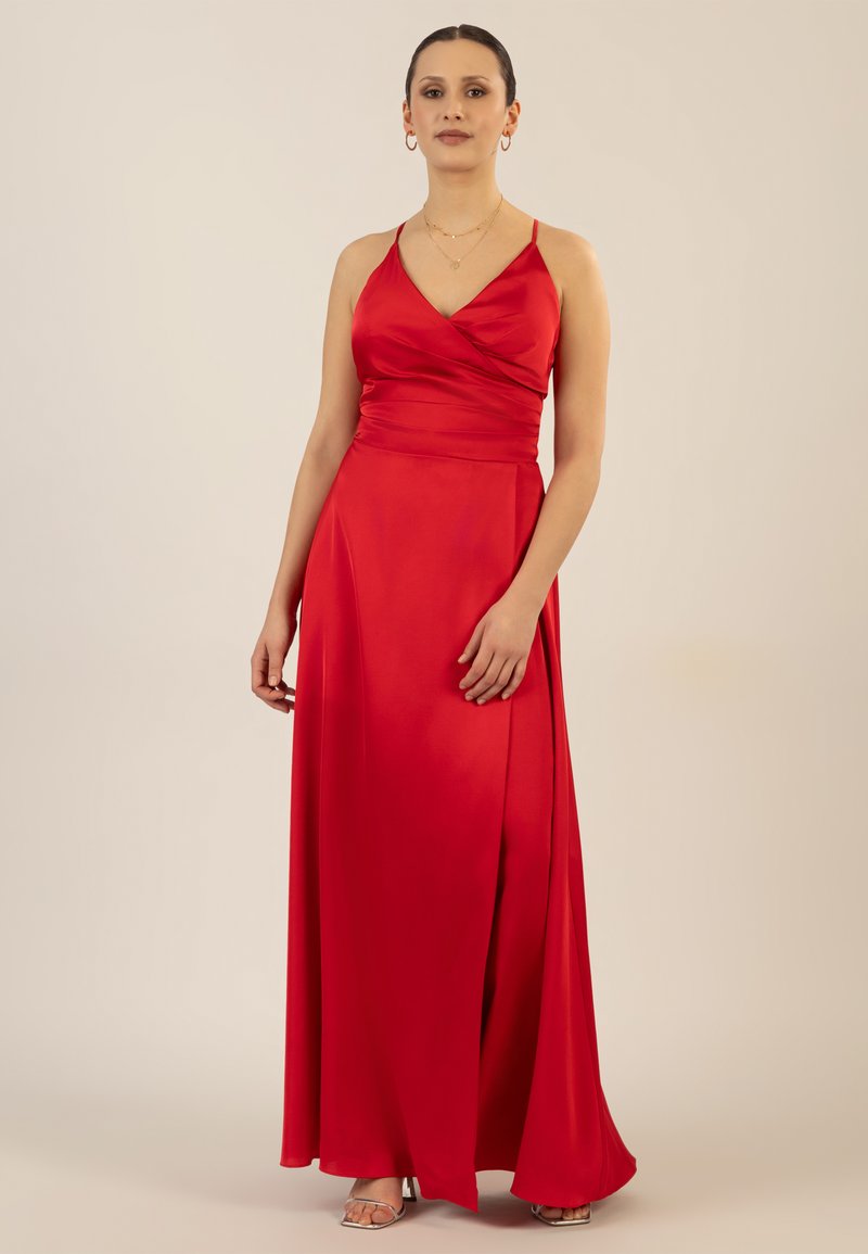 Langes rotes Satin-Kleid mit V-Ausschnitt und Wickel-Oberteil, dünnen Trägern und einem seitlichen Schlitz für zusätzliche Details. Glatte Textur.