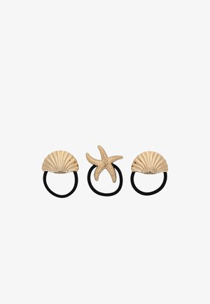 Tre elastici per capelli neri con charm a tema marino in tono oro: due conchiglie e una stella marina, disposti in fila su sfondo bianco.