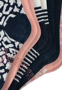 Fire par sokker med forskellige designs: marineblå med hvidt mønster, lyserøde accenter, stribet marineblå og hvid samt et lyserødt blomsterdesign. Blød tekstur.