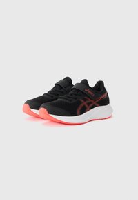 Chaussures de sport noires avec une tige en maille, des accents orange et une semelle blanche. Comprend une sangle Velcro et une semelle extérieure en caoutchouc texturée.