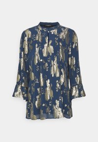 Blusa de color marino con patrón abstracto en dorado metálico, mangas largas con puños con volantes y cuello redondo, hecha de una tela ligera.