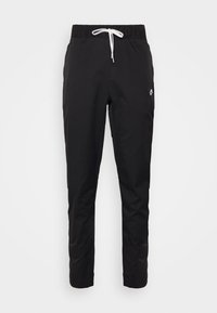 Pantaloni sportivi neri con vita elastica e coulisse bianca. Presentano un piccolo logo sulla coscia e un design a gamba affusolata. Texture liscia.