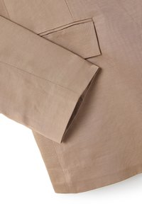 Lichtbruine blazer van een gestructureerde stof, met een geknipte revers, een enkele pocket en schone stiksels langs de randen.