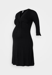Zwarte zwangerschap jurk met een V-halslijn, driekwart mouwen en een strikdetail onder de buste; zachte, rekbare stof voor comfort.