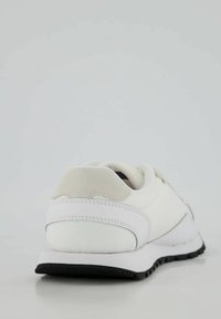 Sneaker bianco con una tomaia in tessuto texture, colletto in schiuma morbida, suola in gomma nera e dettagli di cucitura sottili. Design minimalista nel complesso.