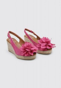 Sandales à talons compensés roses avec une tige en tissu texturé, bout ouvert, accents floraux à l'avant et un design à bride arrière avec une sangle réglable.