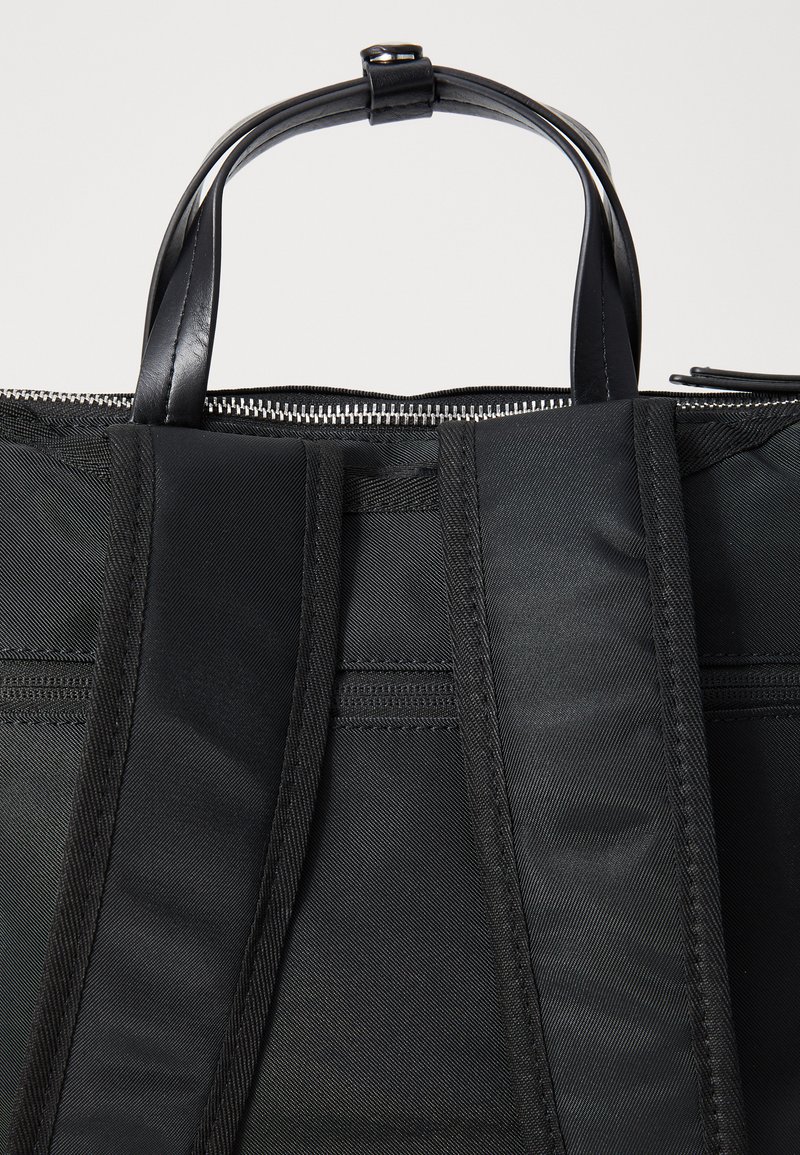 Borsa tote in tessuto nero con dettagli in pelle; presenta due manici robusti, una chiusura con zip e superfici texturizzate con una sottile lucidità.