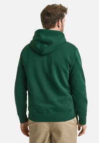 Groene hooded sweatshirt van zachte stof; voorzien van een buidelzak, geribbelde boorden en onderrand. Glad textuur met een ontspannen pasvorm.