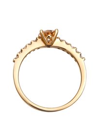 Bague en or avec une pierre précieuse marron doré centrale, accentuée de petites pierres claires le long d'un bandeau texturé et en forme de coquille. Fini lisse.