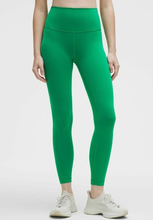 Grüne Hochbundleggings aus einem glatten, dehnbaren Material, mit einem körpernahen Schnitt und nahtloser Verarbeitung bis zum Knöchel.