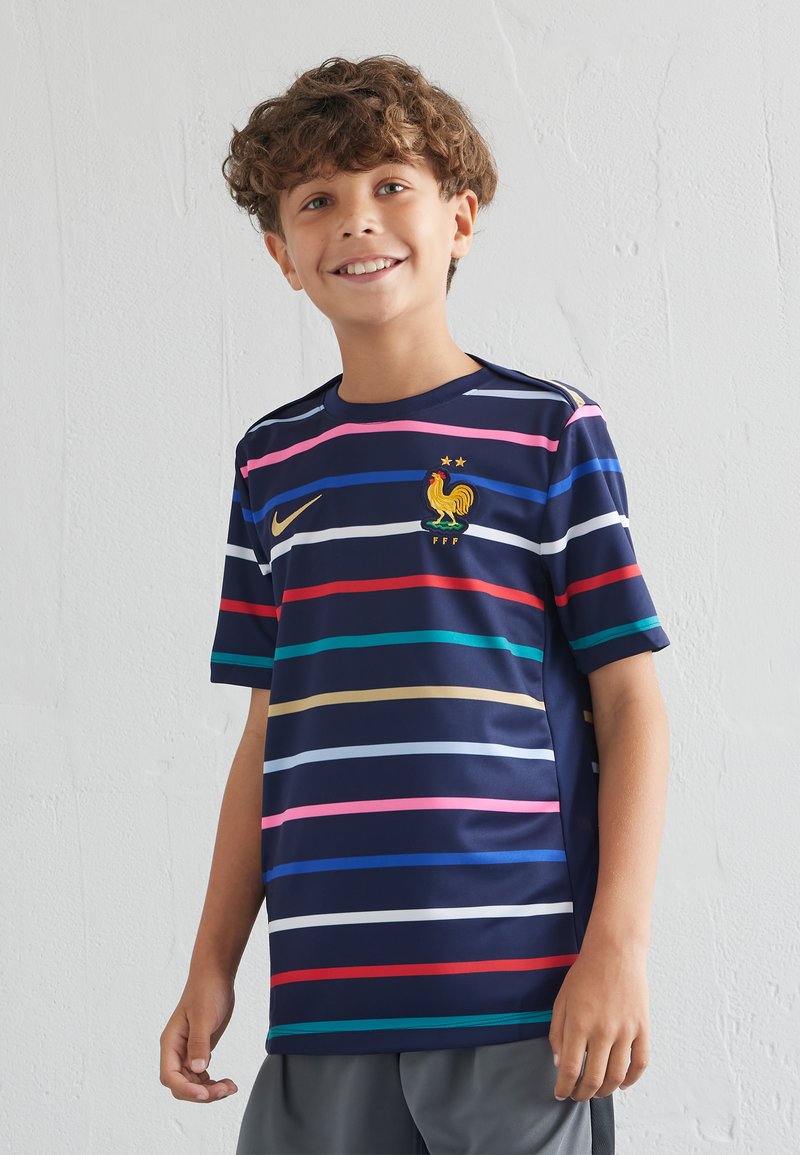 Camiseta de Nike de color azul marino con rayas horizontales en rosa, rojo, verde, amarillo y azul. Presenta un emblema de gallo y la inscripción FFF.