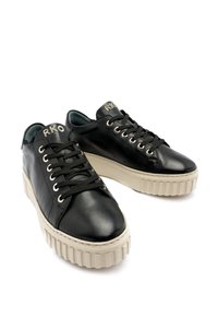 Baskets en cuir noir avec une semelle épaisse de couleur crème, dotées d'une fermeture à lacets et d'un logo sur la languette. Bout légèrement arrondi et côtés perforés.