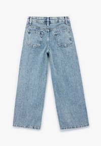 Jasnoniebieskie dżinsy typu wide-leg z tylnymi kieszeniami, prostym krojem i lekko wyblakłą teksturą. Posiadają klasyczny pięciokieszeniowy design.