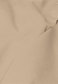 Tissu beige avec une surface lisse et texturée, présentant des motifs de tissage en diagonale et un léger éclat, mettant en valeur sa qualité douce.