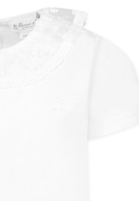 Biała bawełniana koszulka z koronkowym kołnierzykiem, z haftowanymi wzorami kwiatowymi i krótkimi rękawami. Subtelnie umieszczone logo marki.