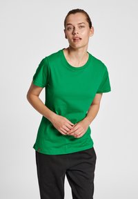 Grön kortärmad T-shirt i mjuk bomullsmaterial med rund halsringning och rak passform. Har en diskret logotypdetalj nära fållen.