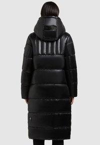 Sort puffed coat med hætte, med kviltede sektioner, glat tekstur og en logoaccent på ryggen nær halsudskæringen.