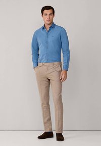 Lichtblauw overhemd van katoen met knopen, gecombineerd met beige op maat gemaakte broek. Het overhemd heeft een aansluitende pasvorm en een subtiele textuur, met een klein logo.