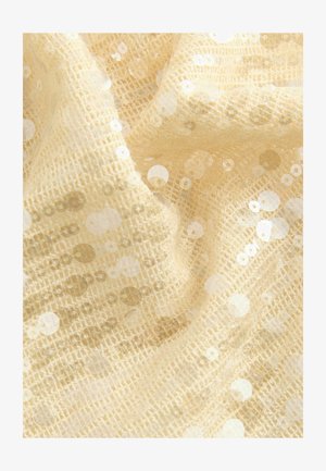 Beežist säärdega kangas, millel on tekstureeritud, kudumtaust, millel on arvukalt ümmarguseid sädeleid, mis peegeldavad valgust ja on erineva suurusega.