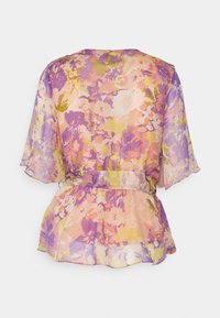 Blouse transparente à motifs floraux pastel violet, rose, jaune, manches courtes volantées et ceinture cintrée à la taille, vue de dos.