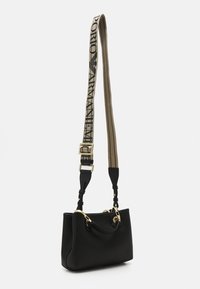 Czarna skórzana torebka o teksturowanej powierzchni, ze złotymi akcesoriami i odpinanym paskiem w paski z logotypem. Prostokątny kształt i dwa uchwyty.