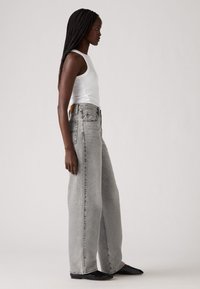 Hoge taille, wijde jeans in lichtgrijs denim met een vervaagd uiterlijk. Voorzien van achterzakken en een leren label op de tailleband.