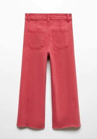 Röda vida byxor i bomull med hög midja, två bakfickor och fransade detaljer vid fållen.