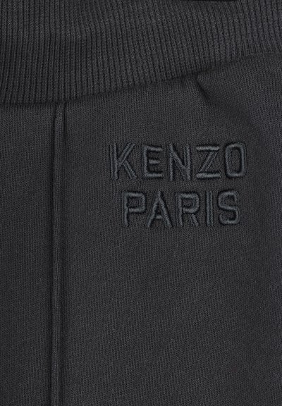 Tissu noir avec texture côtelée et logo brodé "KENZO PARIS" dans une teinte assortie. Design simple et épuré avec des détails minimaux.