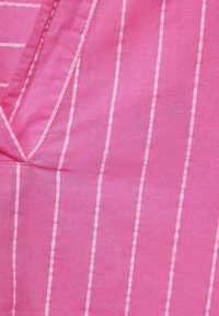 Tessuto rosa con sottili righe verticali bianche, caratterizzato da una texture liscia e un collo a V con cuciture curate.