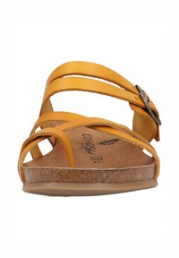 Žluté kožené sandály mají několik tenkých pásků a přezku jako akcent. Texturovaná korková stélka zajišťuje pohodlí a nízký profil podešve.