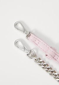 Rosa läderrem med en flätad silverkedja och metallspännen. Slät textur med en sydd detalj på remmen.