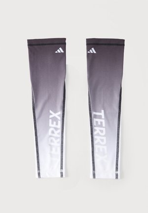 Mouwwarmers in zwart-wit verloop met Adidas-logo vlak bij de bovenkant en "TERREX" verticaal in het wit gedrukt op elke mouw.