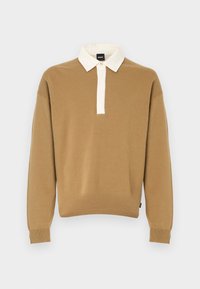 Καφέ πλεκτό πουλόβερ με άσπρο, διπλωμένο γιακά και κοντή κουμπωτή πατιλέτα. Διαθέτει μακριά μανίκια και ελαστικές μανσέτες.