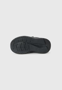 Semelle de chaussure en caoutchouc noir avec un motif texturé pour l'adhérence. Présente un bord incurvé et un motif distinct sur toute la surface pour une meilleure prise.