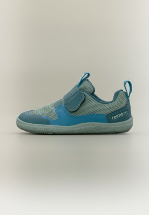 Baskets pour enfants bleu clair et bleu sarcelle en tissu mesh, avec bride en velcro, languettes de tirage sur la languette et le talon, et semelle texturée sur fond neutre.