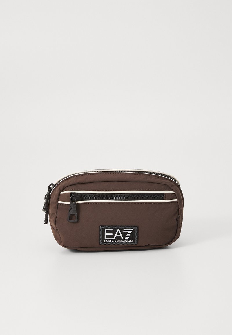 Brun nylon pouch med glidelås og hvite aksentstriper, med et svart EA7-logo-patch på forsiden. Kompakt og avrundet design.