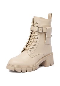 Botoșei bej până la gleznă din piele sintetică, cu un toc masiv, șiret în față, curea cu cataramă și talpă texturată pentru aderență.