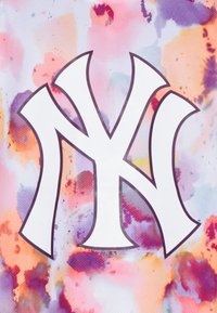 La tela de malla multicolor presenta un destacado logo blanco de los New York Yankees, con un patrón abstracto similar a una acuarela en rosa, naranja y azul.