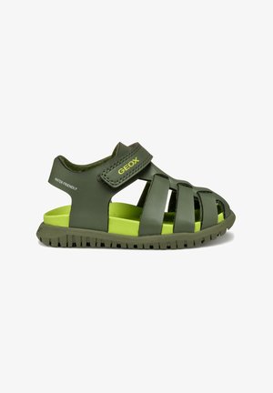 Sandalias Geox verdes con cierre de correa, presentan un diseño en capas y suela de goma texturizada. Material resistente al agua con acentos verdes brillantes.