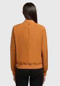 Oranje bomberjack met ribbelmanchetten en -zoom, voorzien van een zachte textuur en minimale details op de achterkant.