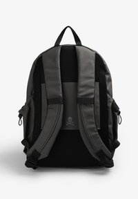 Grijze rugzak met een gepolsterde, mesh achterkant. Heeft verstelbare banden, een bovenhandgreep en een schedellogo. Gladde textuur met nylon accenten.