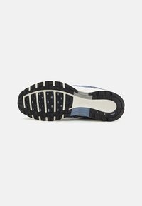 Semelle de chaussure de sport Nike, avec une surface en caoutchouc noir texturé ornée de nuances de bleu clair et de gris, conçue pour l'adhérence et la durabilité.
