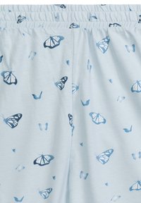 Jasnoniebieska tkanina o miękkiej teksturze, z nadrukiem motyla w ciemnoniebieskim i jasnoniebieskim kolorze. Elastyczny pas u góry.