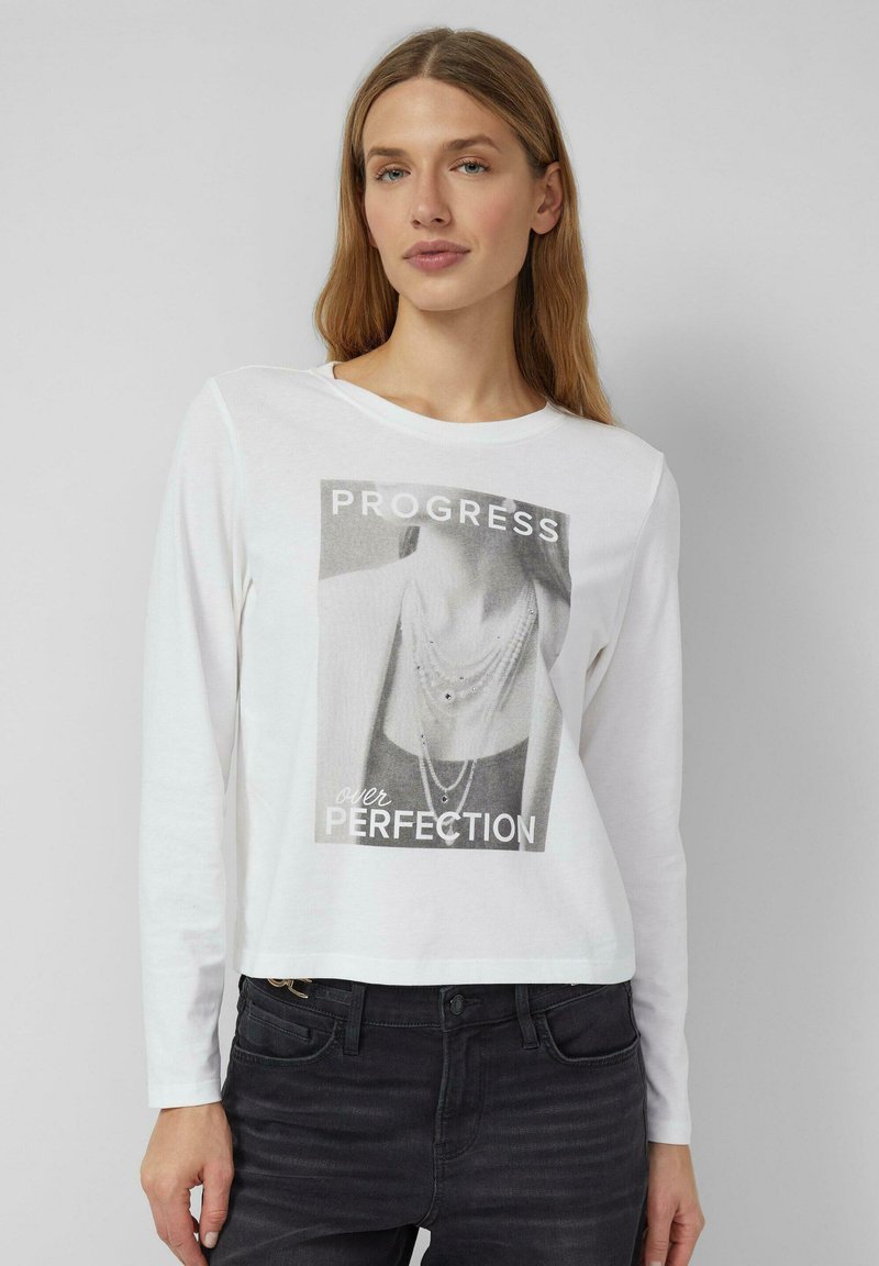 Biała koszulka o długim rękawie z czarno-białym nadrukiem graficznym z napisem "PROGRES ponad DOSKONAŁOŚĆ" i wzorem naszyjnika.