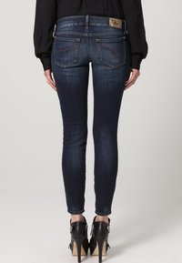 Tunna mörkblå denimjeans med en klassisk femficksdesign, med kontrasterande sömmar och en märkets läderpatch på midjan.