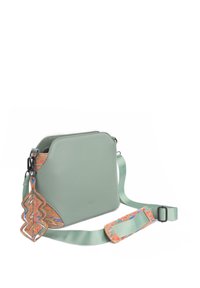 Zelená kabelka v mátovém odstínu se strukturovaným tvarem, korkovými akcenty a vzorovaným popruhem. Disponuje zipovým uzávěrem a odnímatelným přívěskem.