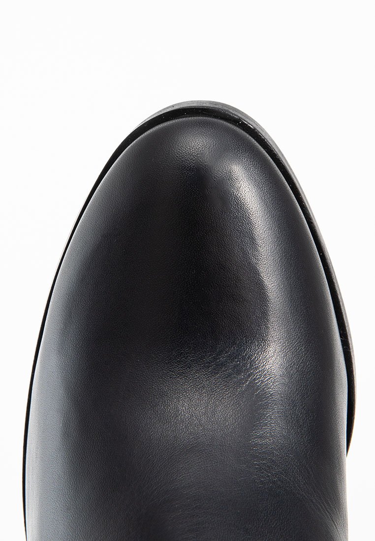 Czarna skórzana обувь z okrągłym noskiem, gładką fakturą i minimalnymi detalami, charakteryzująca się eleganckim wzornictwem i solidną podeszwą.
