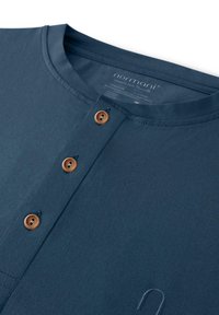 Navyblaue Langarmshirt mit gerippter Struktur, ausgestattet mit einer Knopfleiste mit Holzknöpfen und bestickten Details auf dem Stoff.