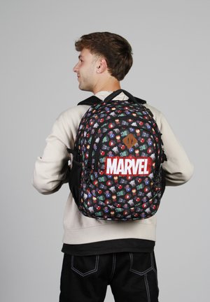 Mochila negra con estampados de superhéroes de Marvel, logo rojo de "MARVEL", múltiples compartimentos, correas de tela y una superficie texturizada.